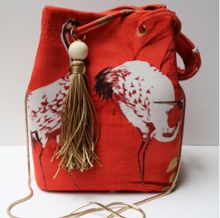 Fabric or leather bucket bag pattern with drawstring, grommets, tassel, and crossbody shoulder strap
